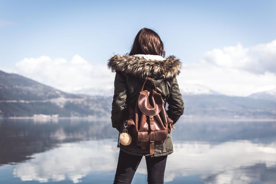Free Image of Woman Standing on Cliff Overlooking Lake 