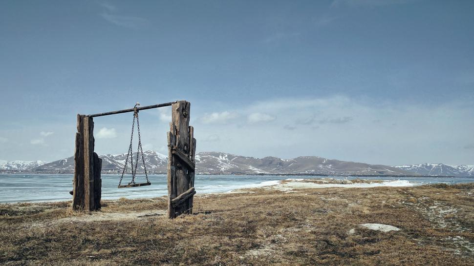 Free Image of Wooden Swing Set on Sandy Beach 