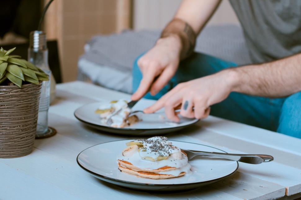 Free Image of Man Cutting Into Food on Plate 