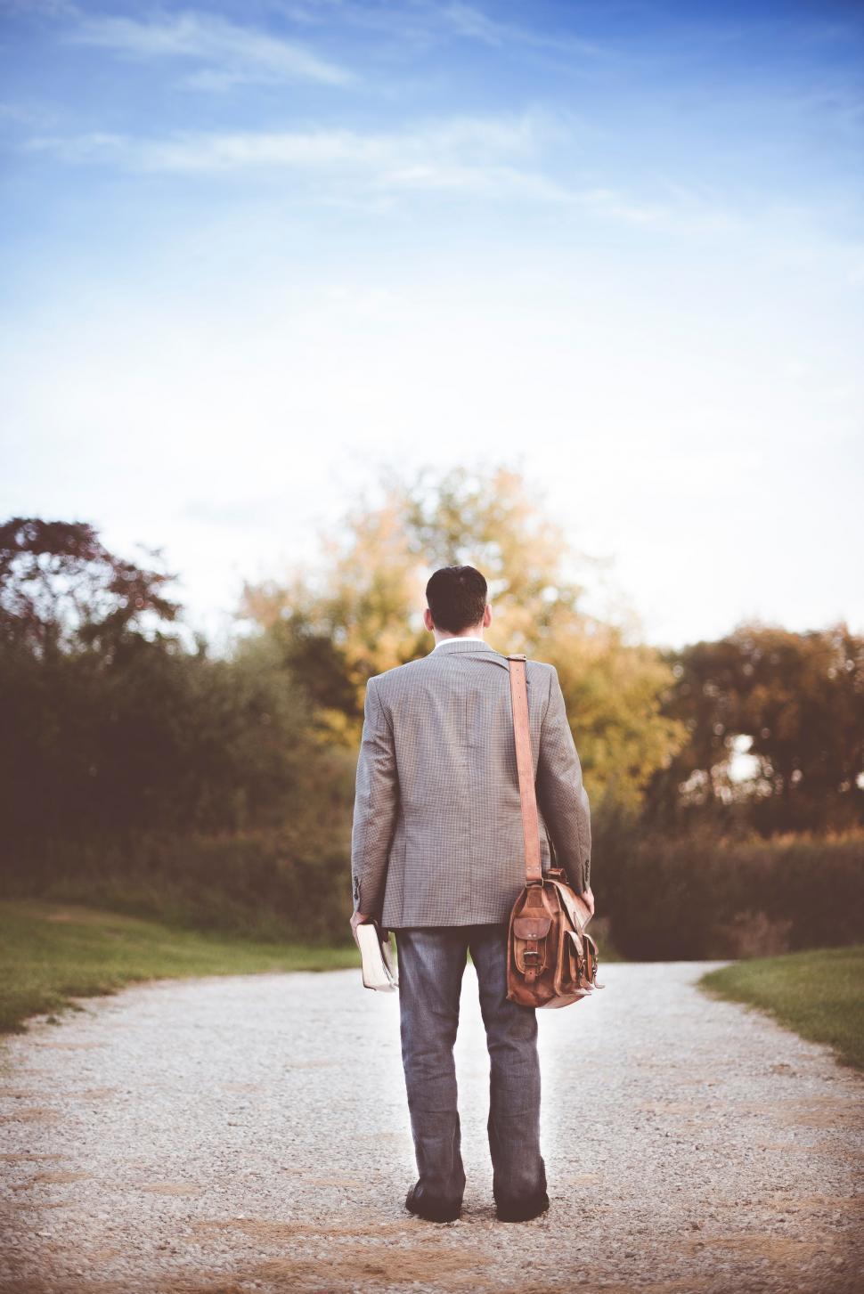 Free Image of Man in Suit Walking Down a Dirt Road 