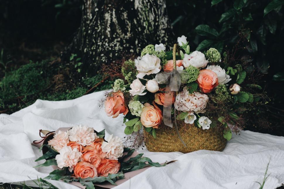 Free Image of Basket Filled With Flowers on Blanket 