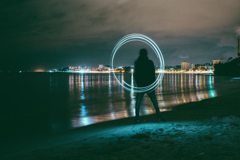 Free Image of Person Standing on Beach Next to Body of Water 