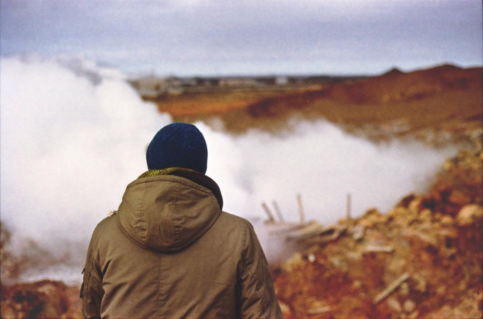 Free Image of Man in Brown Jacket Observing Geyser 