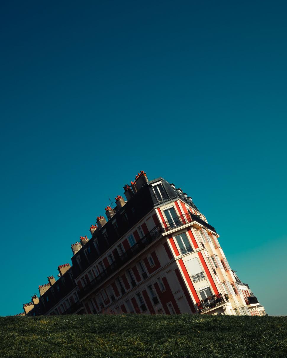 Free Image of Tall Building Towering Over Lush Green Field 