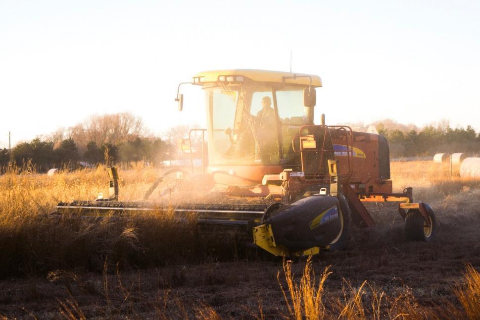 Free Image of Tractor Driving Through Field of Grass 