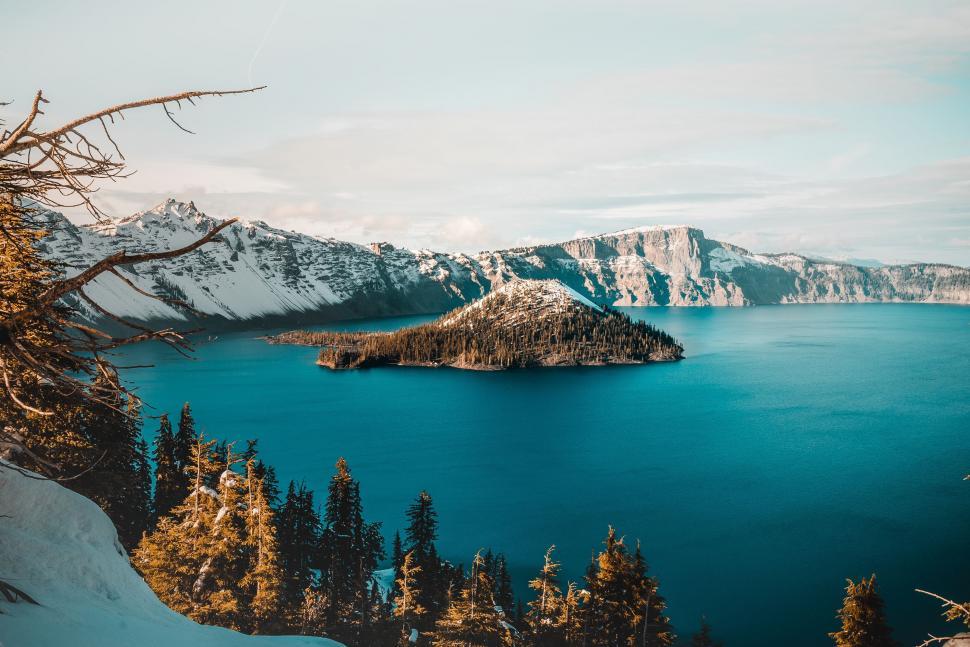 Free Image of Majestic Snow-Covered Mountains Surrounding Large Body of Water 