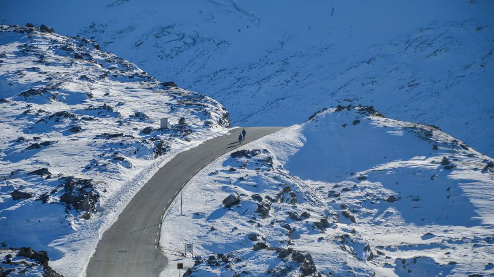 Free Image of Person Riding Snowboard Down Snow Covered Mountain 