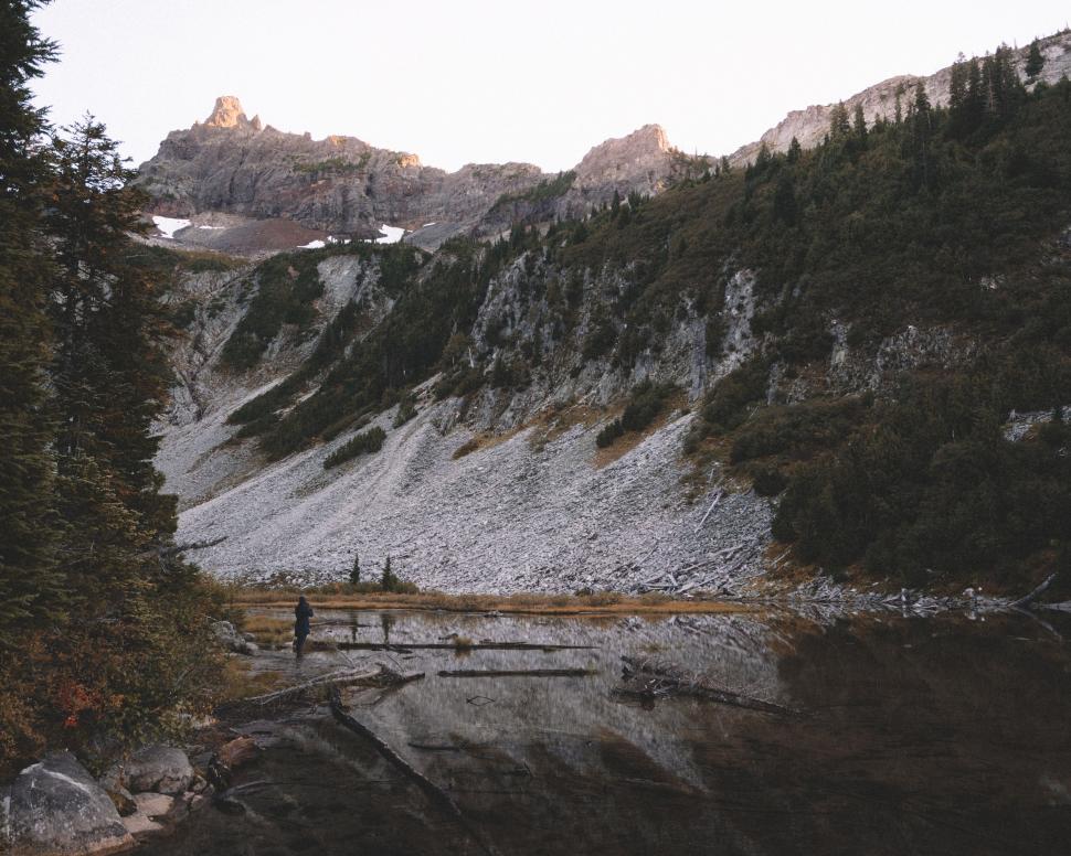 Free Image of Man Standing on Bridge Over River 