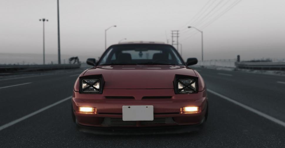 Free Image of Red Sports Car Driving Down Highway 