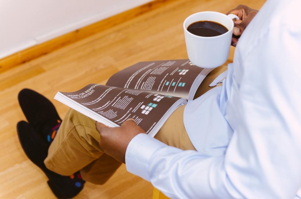 Free Image of Man Reading Newspaper and Holding Coffee Cup. 