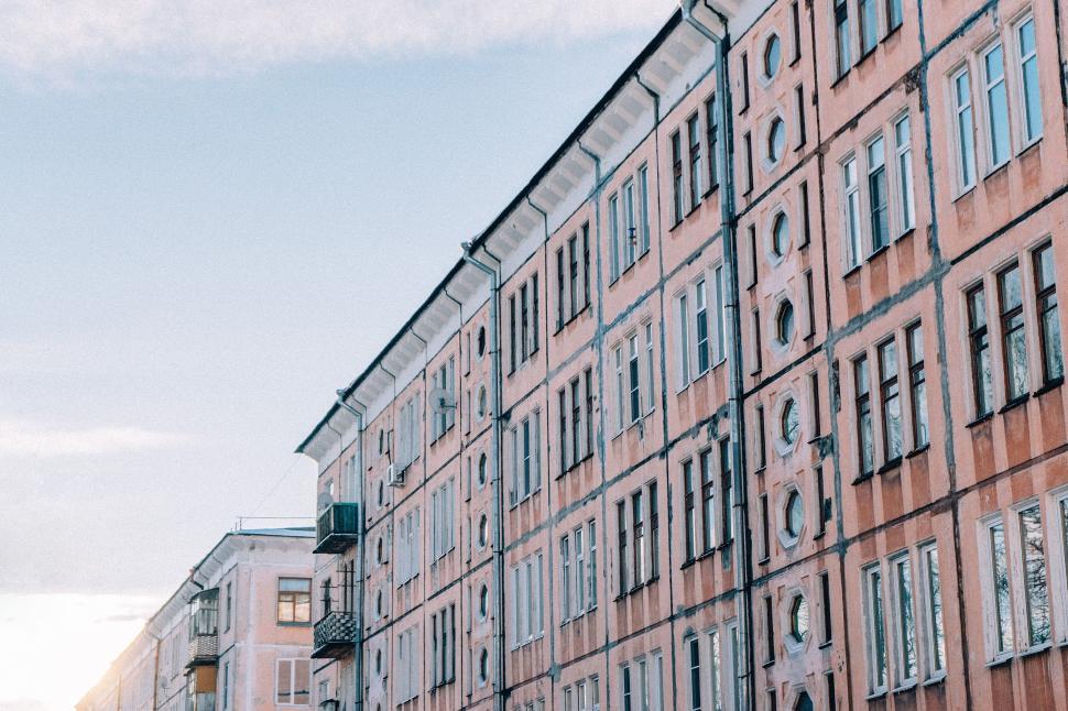 Free Image of Tall Building With Lots of Windows Next to a Street 