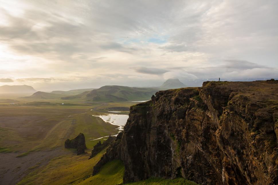 Free Image of Man Standing on Cliff by Water 