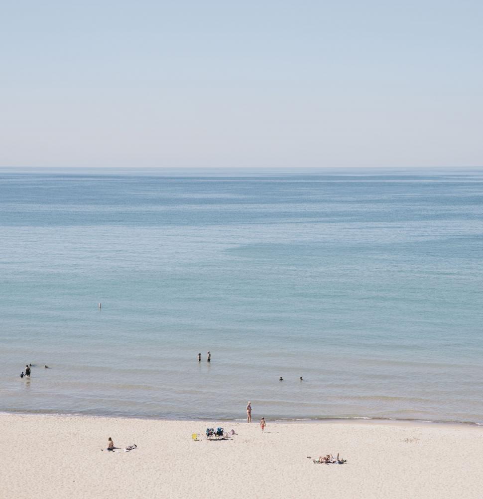 Free Image of Group of People Standing on Top of a Sandy Beach 
