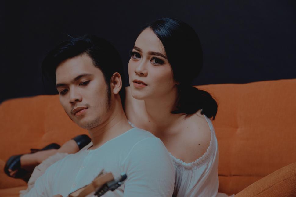 Free Image of A Man and a Woman Sitting on a Couch 