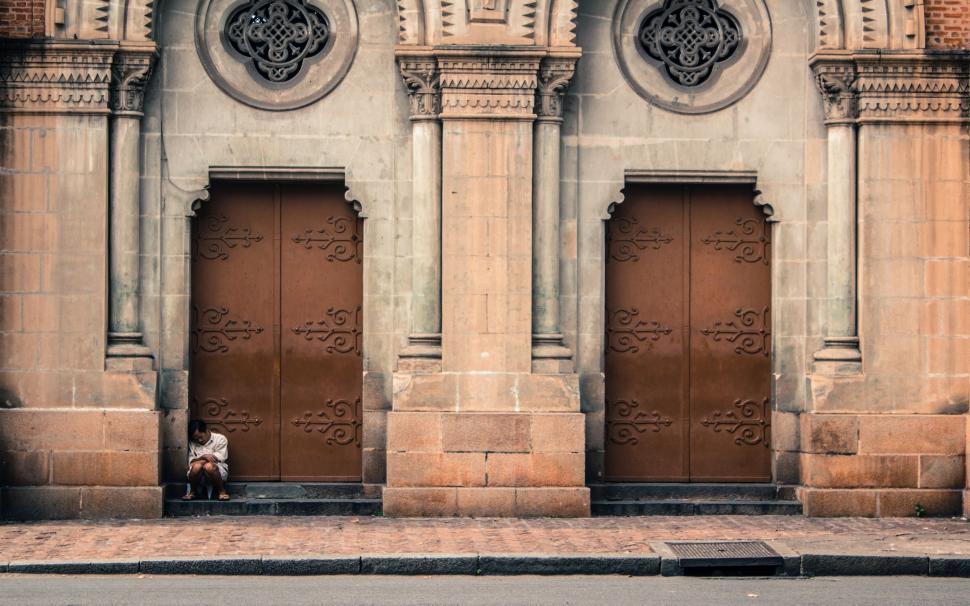 Free Image of Person Sitting on Bench in Front of Building 